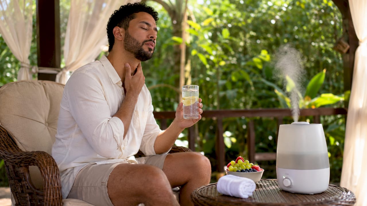 Male singer practicing voice rest with water